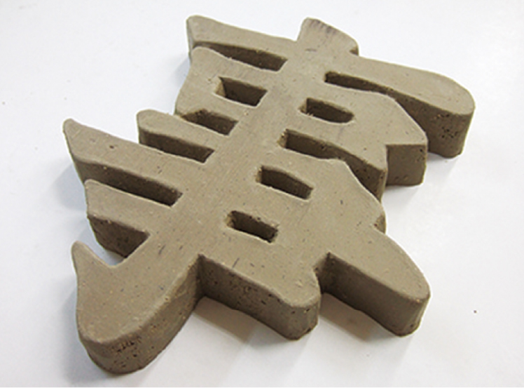 文字づつ陶板から手削りします（焼成前）
